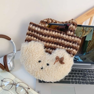 Detail of cute plush bear tote bag featuring brown striped knit and soft white fur texture