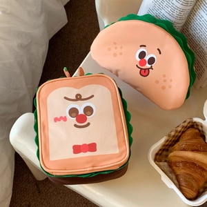 Detail view of plush toast and taco makeup bags with cute facial embroidery and zip closure
