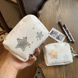 Minimalist white star pattern cosmetic pouch set with silver metallic stars on wooden table