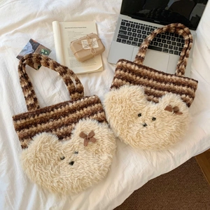 Detailed close-up of striped knit tote bag with a cute plush bear face and bow accent