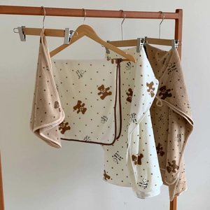 Plush polka dot bear coral fleece towel set in cream and brown on a wooden hanger