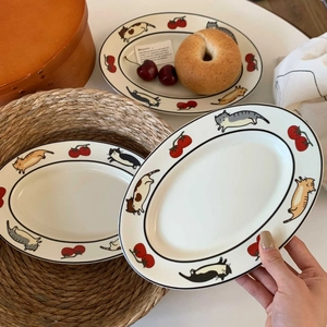 Gros plan d'une assiette ovale en céramique avec motifs chats de dessin animé et tomates
