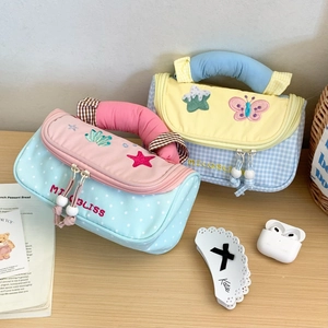 Detailed close-up of quilted cotton pencil cases with embroidery and pearl zippers