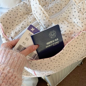 Close-up of quilted floral tote bag showing side pocket on a suitcase for travel