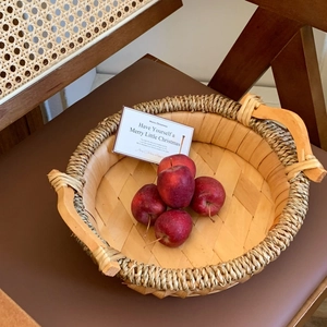 Round woven fruit basket with handles made of natural wood strips for home storage