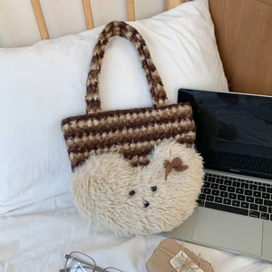 Detail of striped plush tote bag with cute bear patch next to a laptop
