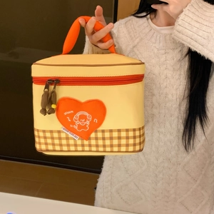 Detail of insulated lunch bag featuring cartoon bear embroidery and checkered pattern