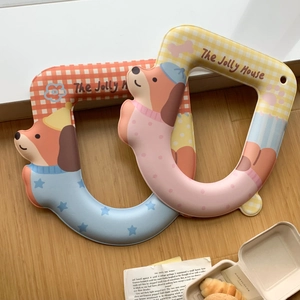 Detail view of waterproof dachshund cartoon toilet seat pads on a wooden floor