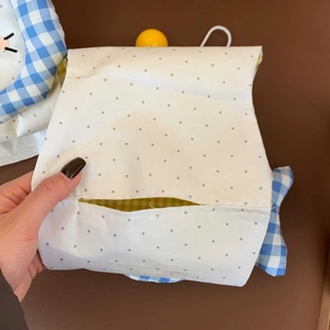 Detail of cute cat tissue bag featuring white fabric with gray polka dots and checkered lining
