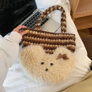 Detail of cute striped plush tote bag with large teddy bear head and brown bow accent