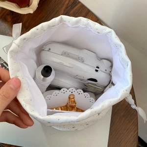 Internal view of star pattern drawstring pouch showing storage capacity for camera and cosmetics