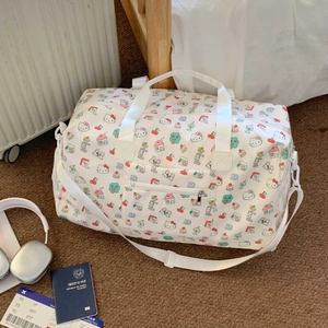 Detail of Hello Kitty pattern on white duffel bag with shoulder strap and handles