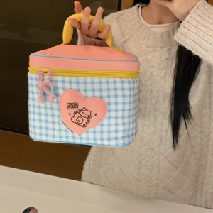 Detail of blue checkered insulated lunch bag with cute cat patch and pink zipper closure
