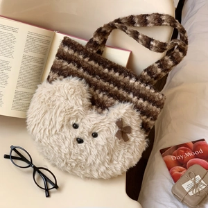 Detail of plush bear tote bag with striped handles and ribbon on a cozy lifestyle setup