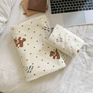 Close-up of soft coral fleece towel set featuring cute bear prints and brown polka dots