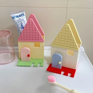 Dettaglio dei portaspazzolini da parete a forma di casa in colori pastello per il bagno