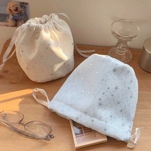 Close-up of star pattern drawstring storage bags in cream and light blue canvas fabric