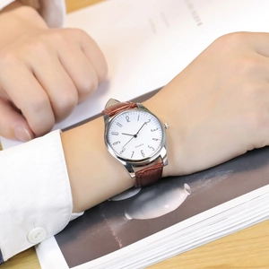 Detailed close-up of brown crocodile texture leather strap on a classic quartz business watch