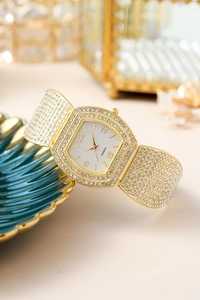 Macro shot of luxury gold tonneau watch with crystals on a shell-shaped display tray