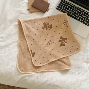 Close-up of brown polka dot bear towel with soft coral fleece and hanging loop detail