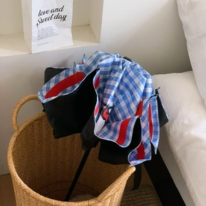Cute star apple star umbrella with blue and white checkered liner in a brown basket