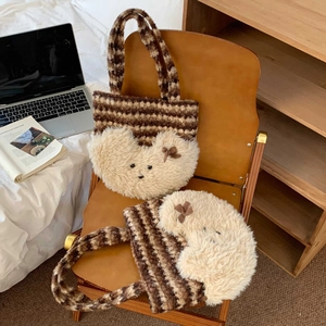 Detail of cute striped plush tote bag with bear face design on a brown leather chair