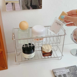 Macro view of double-layer stainless steel storage rack holding perfumes and cosmetics