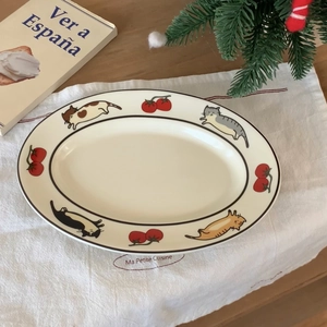 Détail d'une assiette ovale en céramique blanche avec chats mignons et motifs tomates