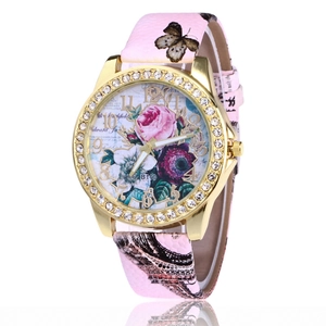 Close-up of golden rhinestone watch with rose pattern dial and pink leather strap