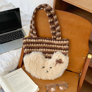 Detail of cute striped plush tote bag with 3D bear motif on a cozy wooden chair