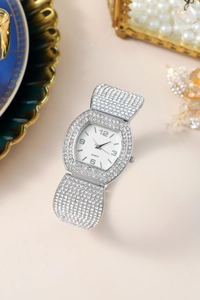 Detail of tonneau silver luxury watch for women with rhinestones and white quartz dial