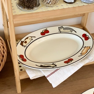 Vue détaillée d'une assiette ovale en céramique avec motifs chats et tomates peints