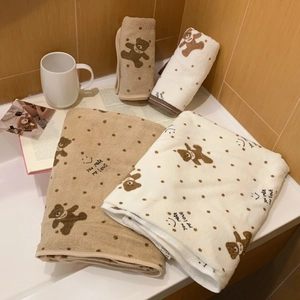 Close-up of soft coral fleece towels with cute bear patterns and polka dots