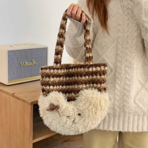 Detail of plush tote bag featuring striped knit texture and soft white faux fur trim