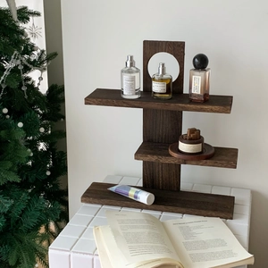 Detail of multi-tier walnut solid wood shelf displaying perfumes in a cozy home setting