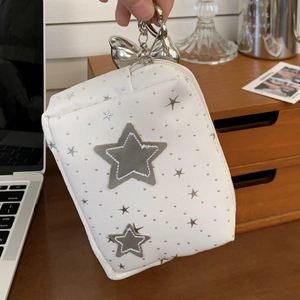 Detailed shot of star pattern mini bag with metal carabiner hook and bow accessory