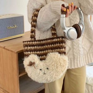 Detail of plush tote bag featuring a fluffy teddy bear appliqué and brown striped texture