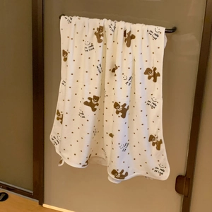 Detail of white fleece towel featuring cute brown bear prints and polka dots pattern
