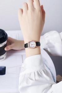 Elegant vierkant dameshorloge met zwarte leren band gedragen in een lifestyle setting