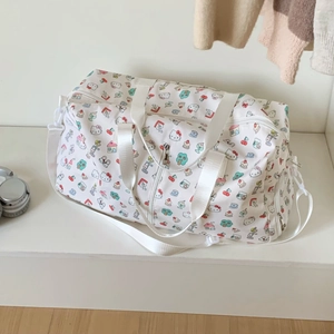Detail of white travel bag with cartoon cat print showing smooth zippers and handles