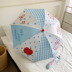 Close-up of stars and apples pattern on light blue folding umbrella with matching sleeve