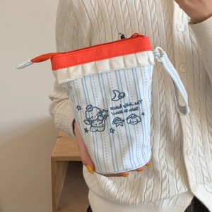 Dettaglio del ricamo carino sull'astuccio a righe con decorazioni a volant eleganti
