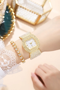 Detail of luxury gold tone women watch and heart bracelet with shimmering rhinestones