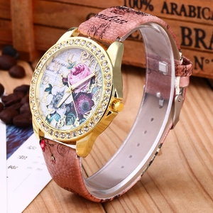 Elegant rose floral quartz watch with rhinestone bezel and textured strap on a vintage base