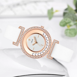 Detalle de reloj oro rosa con cristales brillantes y correa de cuero blanco liso
