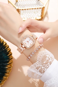 Dettaglio dell'orologio quadrato in strass oro rosa con bracciale a cuore abbinato al polso