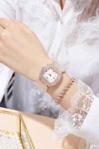 Close-up of rose gold tonneau watch and heart bracelet with sparkling rhinestones