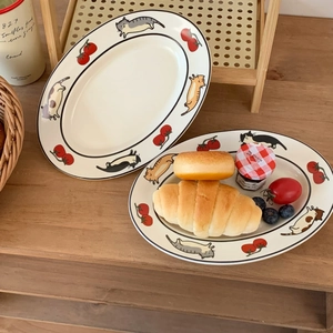Détail de l'assiette ovale en céramique avec motifs chat et tomate et un croissant