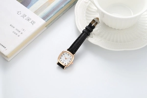 Bovenaanzicht van vintage vierkant quartzhorloge met zwarte lederen band op bureau