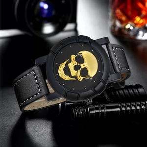 Macro view of men's watch featuring a golden skull dial and leather strap with white stitching